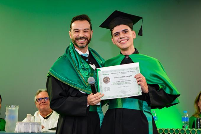 Dr. José Oliveira Costa Filho entrega o certificado de melhor aluno para Gabriel José Oller Pereira
